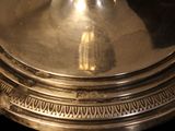 a silver plate with a candle on top of it