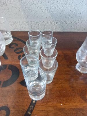bottles and glasses on a wooden table with a stencil on the wall