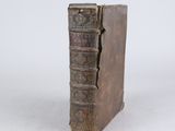 an old book sitting on top of a white surface