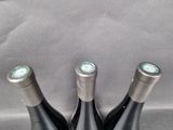 three bottles of wine sitting on top of a table next to each other