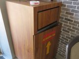 une armoire en bois sur laquelle est posé un micro-ondes, à côté d'une chaise
