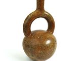 un petit vase marron muni d'une anse, posé sur une surface blanche