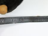 a stuffed animal that is sitting next to a ruler