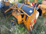 a tractor that is sitting in the grass with a plow behind it