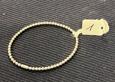 un bracelet muni d'une étiquette, posé sur une table