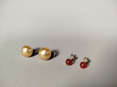 trois paires de boucles d'oreilles à clous en perles et corail sur un fond blanc