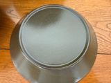 a bowl on the table next to a plate on the floor