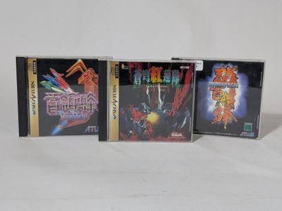 three video game cases sitting next to each other on a white surface