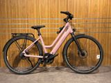 un vélo rose garé devant un mur en bois