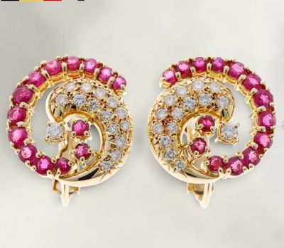 une paire de boucles d'oreilles en diamants roses et blancs posées sur un fond blanc