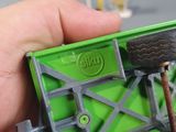 a person holding a green toy truck with wheels