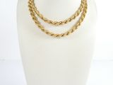 a close up of a mannequin with a gold necklace on it