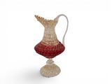 a glass vase with a handle on a white surface