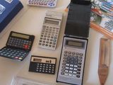 une table sur laquelle sont posées de nombreuses calculatrices