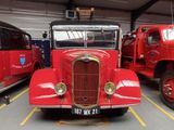 a red truck parked in a garage next to other trucks