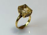 an image of a gold ring with a green stone in the center