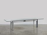 une table en verre avec des pieds en métal et un plateau en verre