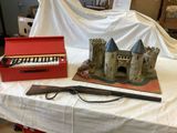 a red box and a gun on a table with a white sheet