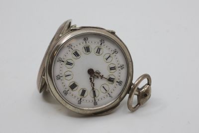a silver pocket watch with roman numerals on the face