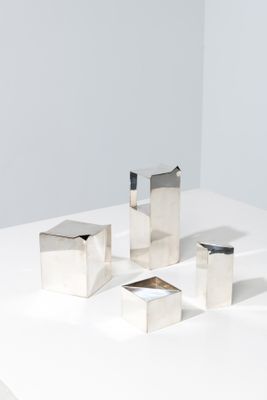 quatre pièces métalliques argentées sur une surface blanche