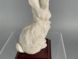 a white rabbit statue sitting on a red base
