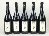 quatre bouteilles de vin sont alignées sur une surface blanche