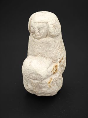 un gros plan d'un objet en pierre blanche posé sur une surface noire