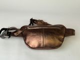 a close up of a brown leather fanny bag on a white surface