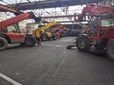 many different types of construction equipment parked in a warehouse