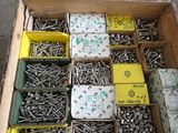 many boxes of screws in a box on the ground