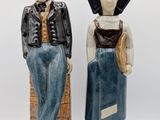 two figurines of a man and a woman standing next to each other