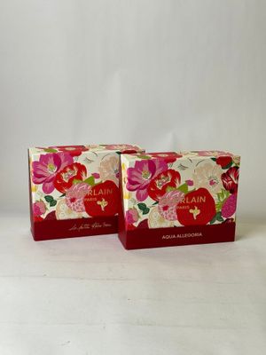 two boxes of soap sitting on top of a white surface