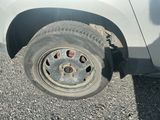 un pneu crevé sur le côté d'une voiture blanche