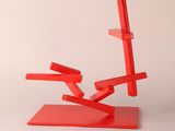 a red sculpture on a white surface with a white background
