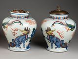 pair of chinese vases with dragon and phoenix designs on them