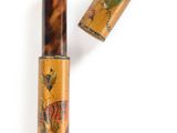 a close up of a bottle of liquid next to a wooden tube