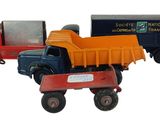 plusieurs camions jouets sont alignés sur une surface blanche
