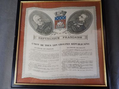 une photo encadrée représentant deux hommes en costume et un blason