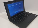 the laptop is open on a white table with a blue screen
