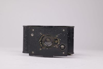 un appareil photo noir posé sur une surface blanche