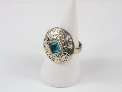 a close up of a ring with a blue stone in it