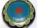 a black and green bowl with a red square in the center