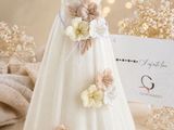 a white dress with flowers on it next to a place card