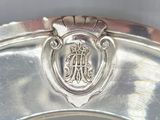 an image of a silver plate with a crest on it