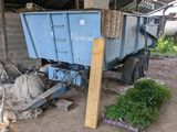 un camion-benne bleu garé à côté d'un tas d'ordures