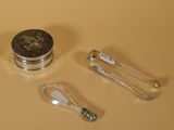 un récipient en argent avec une cuillère et un repose-cuillère à côté