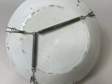 a white clock with a black handle on a white surface