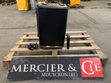 a television sitting on top of a pallet in the middle of a parking lot