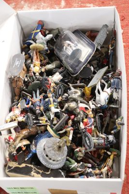 une boîte remplie de jouets de toutes sortes posée par terre