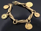 un gros plan d'un bracelet en or orné de pièces de monnaie, posé sur une surface noire